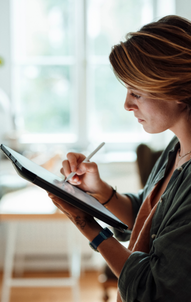 Woman taking notes on a tablet, using a stylus