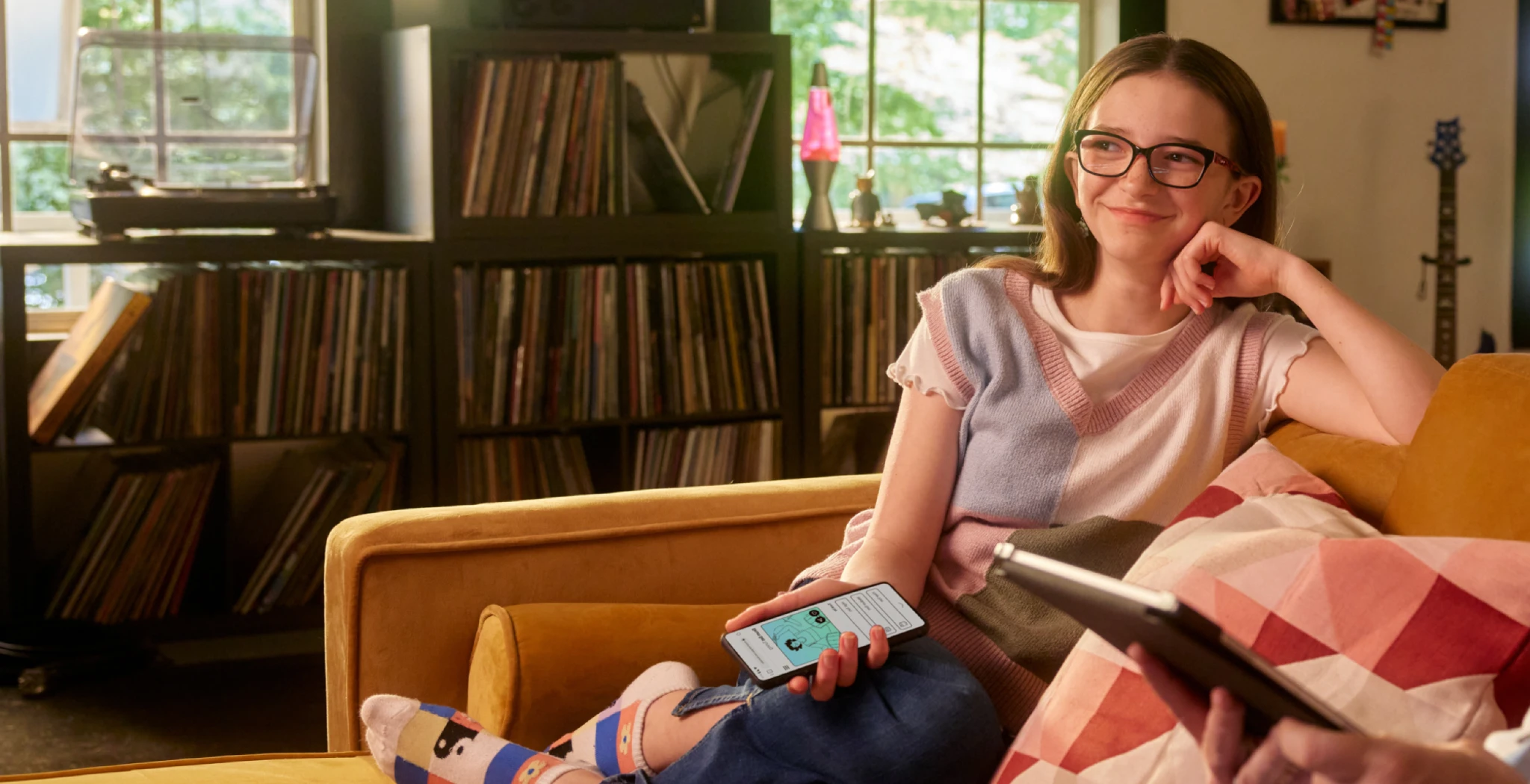 Man and girl sitting on the couch with a phone and tablet connected to Brightspeed fiber internet.